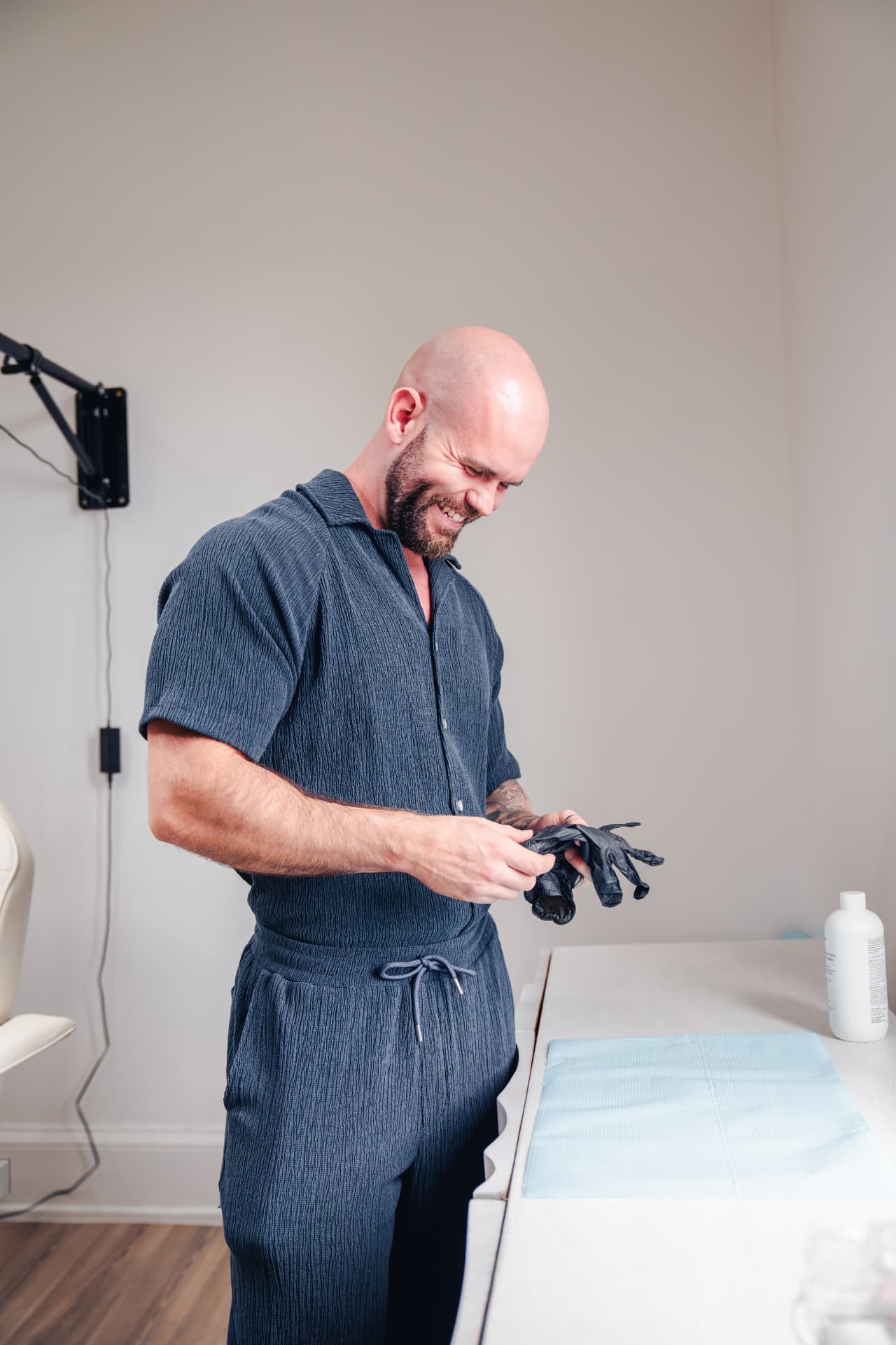 Sam smiling as he puts on gloves in the clinic
